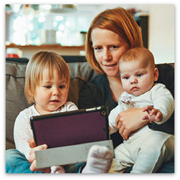 Mother reading to a toddler and baby.